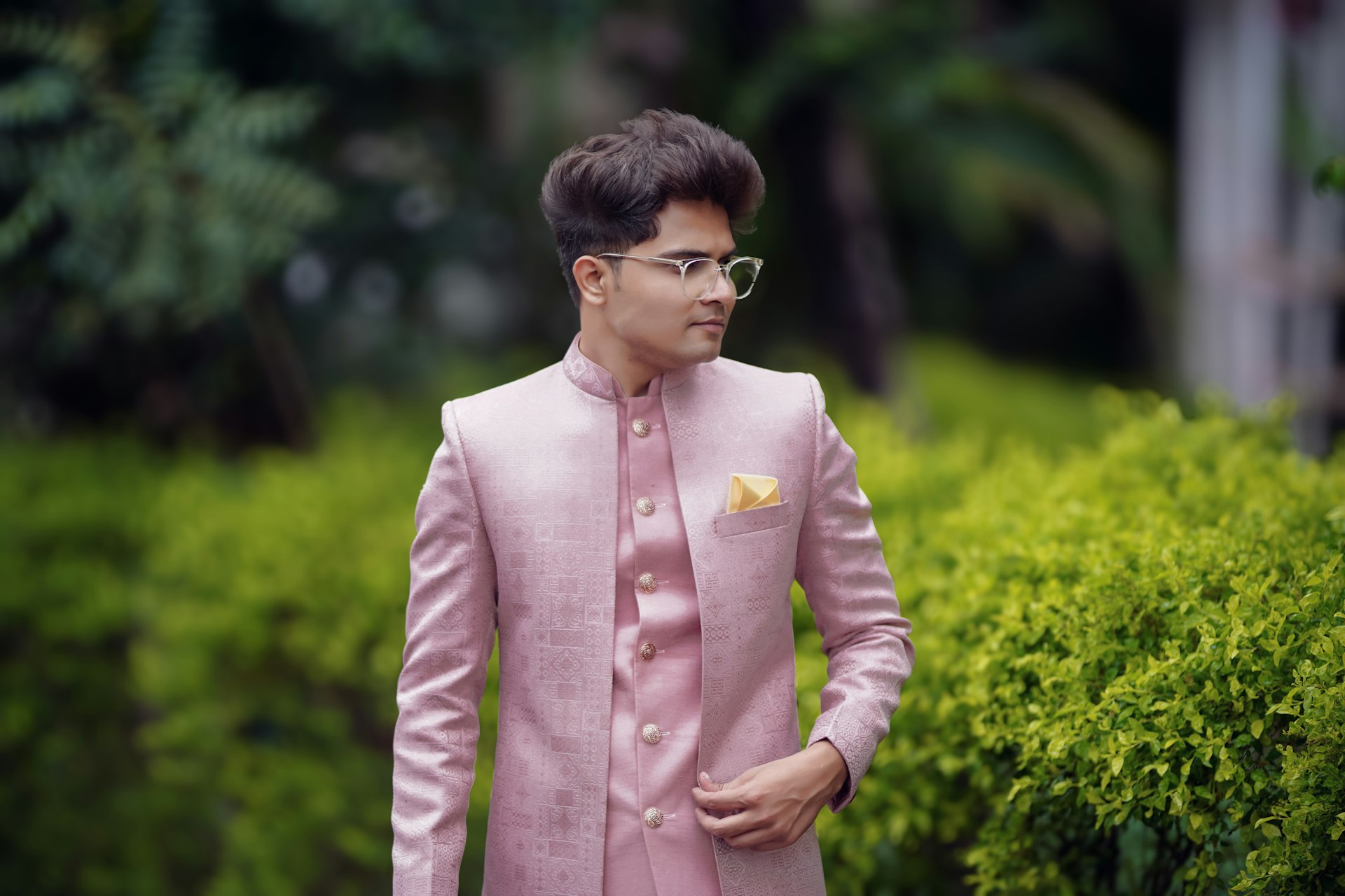 A man wearing a pink suit and glasses